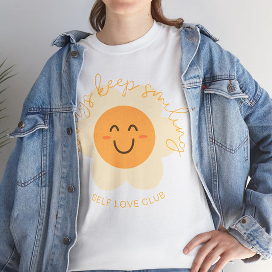 Person wearing a white t-shirt with a flower graphic and text, paired with a denim jacket.