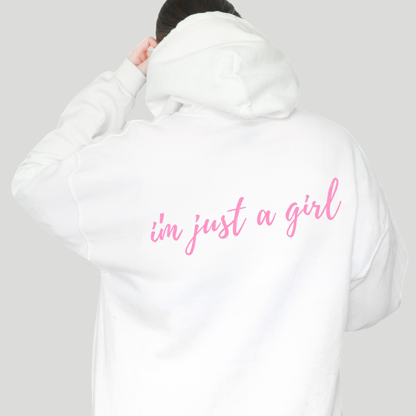 White hoodie with 'i'm just a girl' text on the back against a gray background