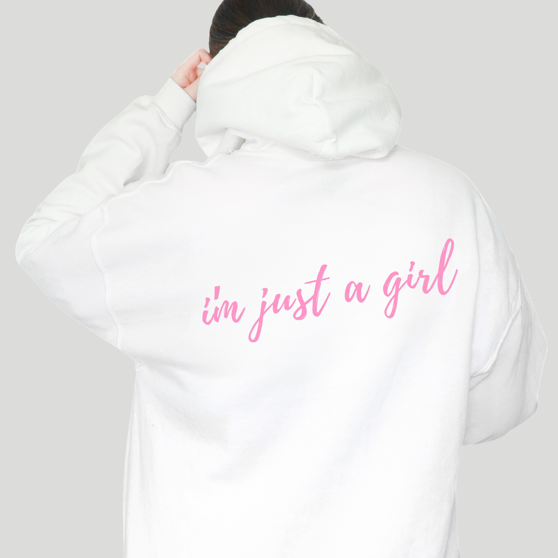 White hoodie with 'i'm just a girl' text on the back against a gray background