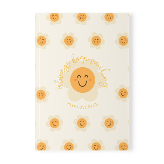 Notebook with happy flower face design and text on a white background