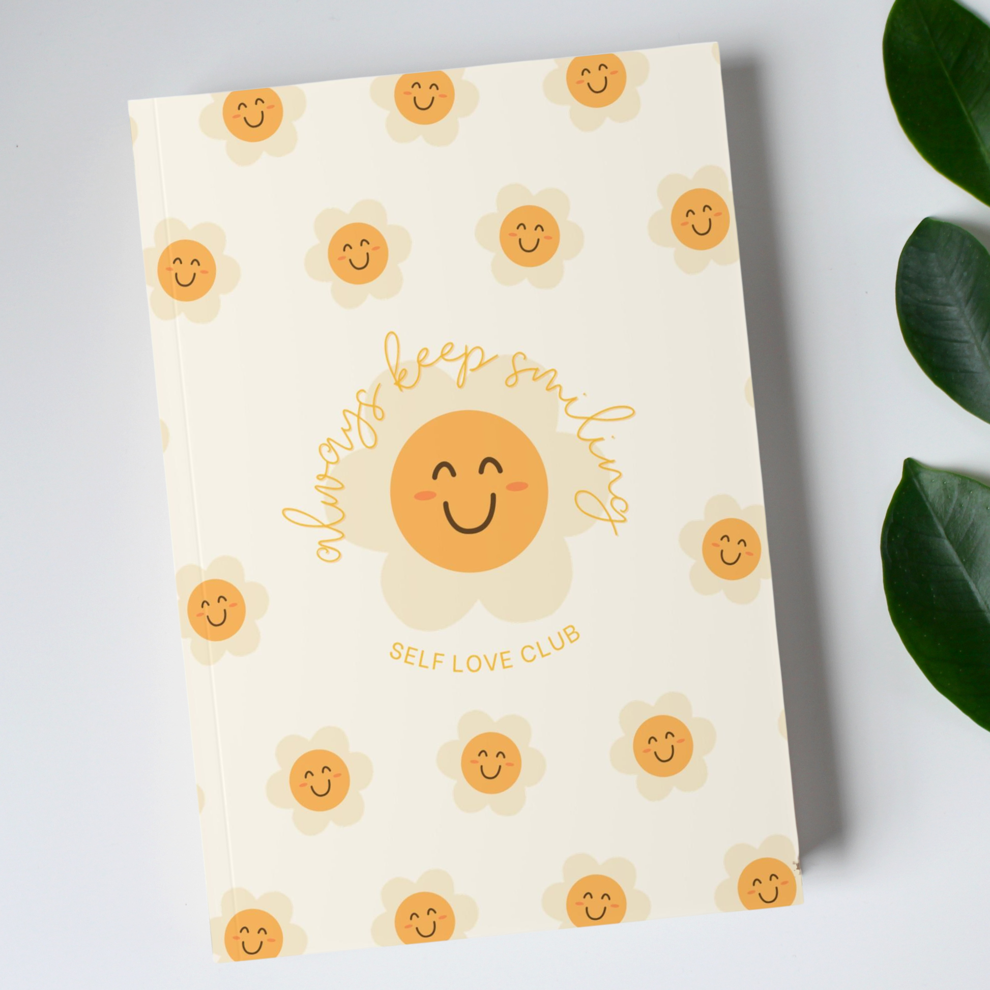 Notebook with happy flower face design and text on a light gray background