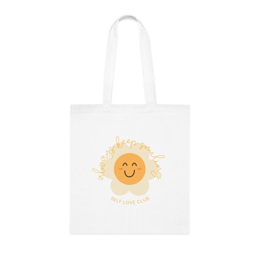 White tote bag with a sunflower design and 'Self Love Club' text on a white background