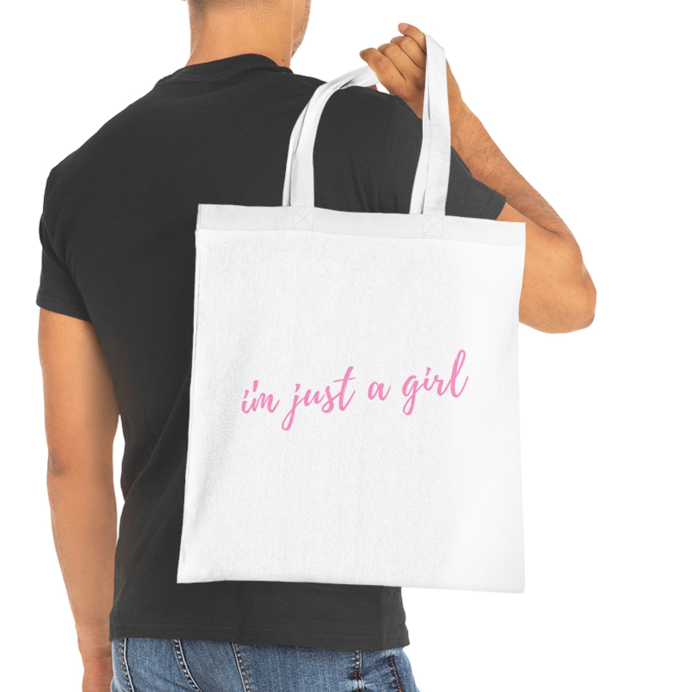 Man holding a white tote bag with 'I'm just a girl' text on a white background