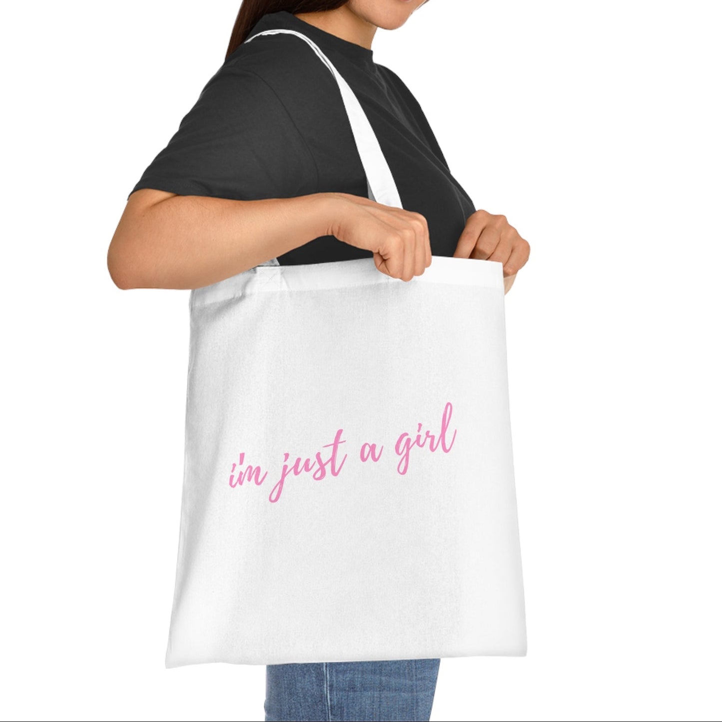 Woman holding a white tote bag with 'I'm just a girl' text on a white background